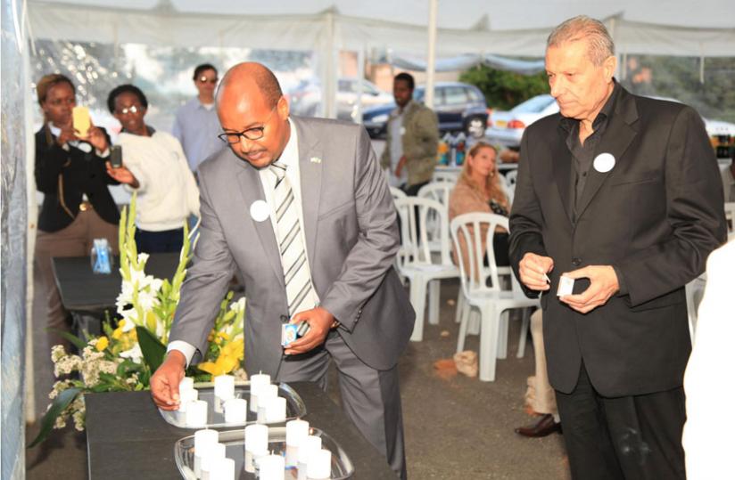 Amb. Col. Joseph Rutabana (L) lighting a candle with a friend of Rwanda. (Courtesy)