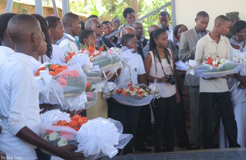 Grandchildren of victims of the Genocide queue to lay wreaths on a tomb. (Stephen Rwembeho)