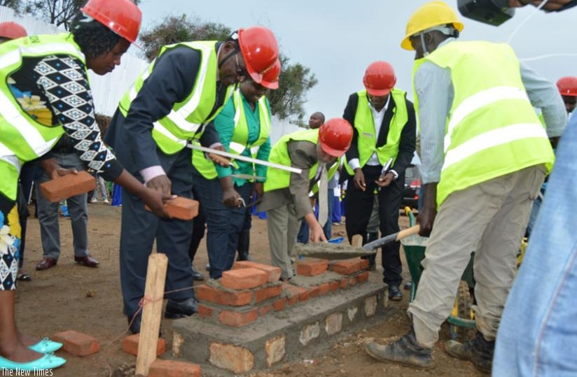 Governor Mukandasira (L) and Minister Kanimba (2nd left) lay the foundation of a new market to be constructed in Karongi. (S. Muvunyi)
