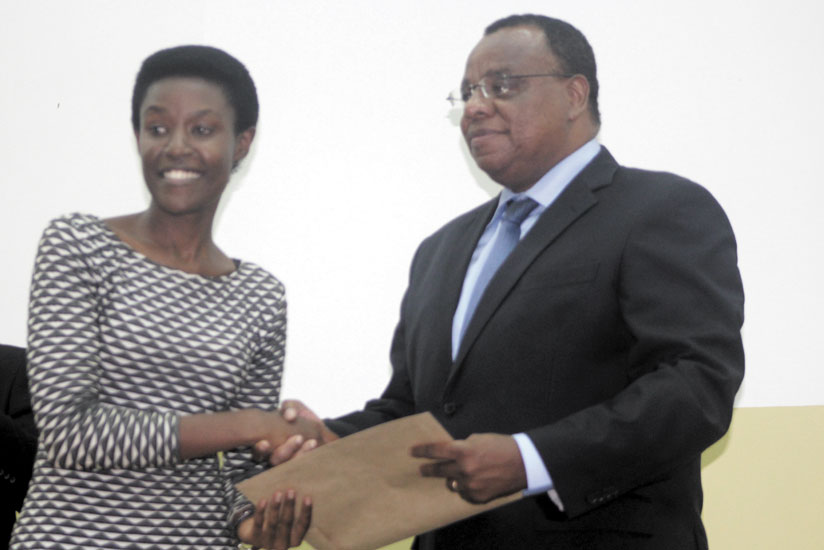 The Kenya High Commissioner to Rwanda, H.E. John Mwangemi (R) handing over a CPA certificate to Jeanne Abayo, one of the graduates, at UR-CBE in Kigali on Thursday. (Courtesy)