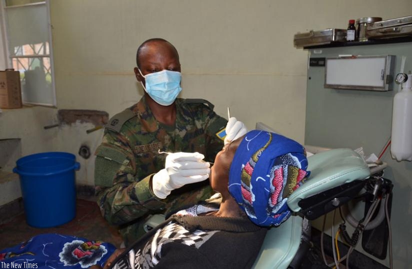 An army officer attends to a patient during the Army Week campaign in Muhanga District. (Frederic Byumvuhore)