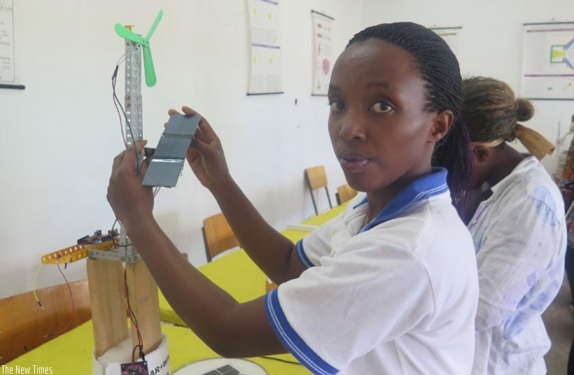 A student experimenting with a  solar and wind hybrid green tower as part of her research project.  (Solomon Asaba)