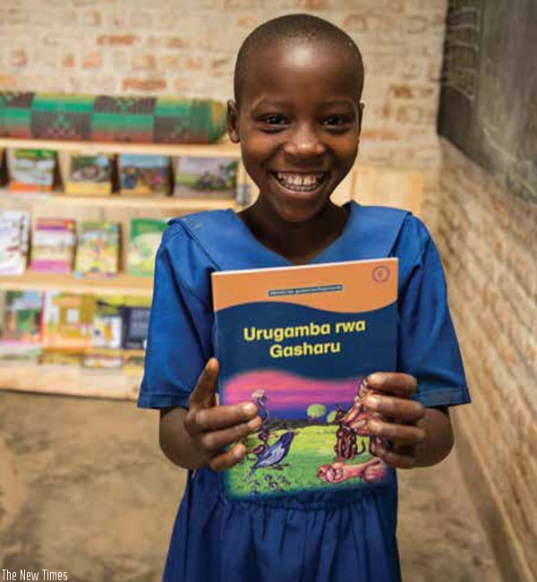 A pupil holds a Kinyarwanda storybook. (Net photo)
