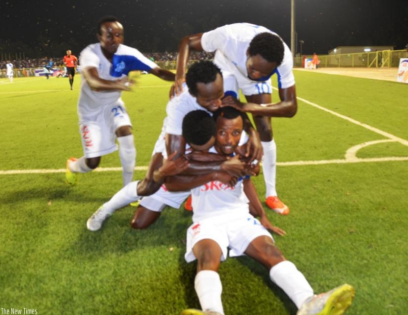 Rayon Sports' Savio Nshuti (foreground) is mobbed by his teammates after scoring the third goal in the 3-1 win over Police on Saturday. rn(S. Ngendahimana)