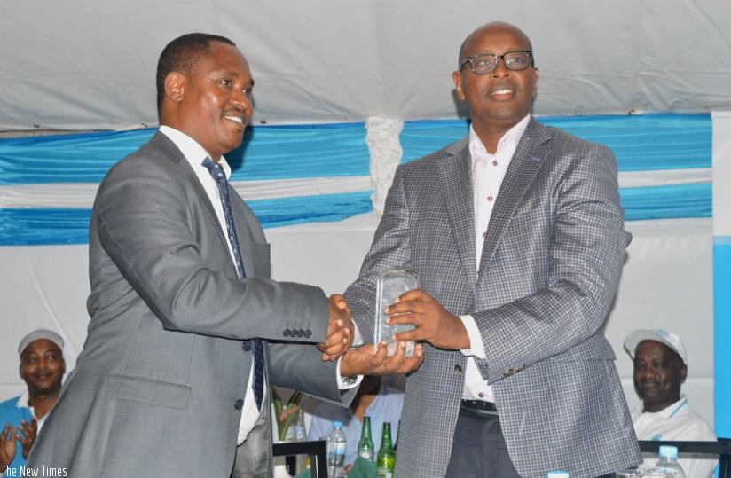Sano (L) presents the Global Water Leaders' Award to Musoni during May Day celebration on Sunday. (Emmanuel Ntirenganya)