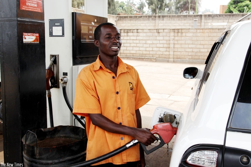 A pump attendant refills a car. Fuel pump prices have increased to Rwf 860 (File)