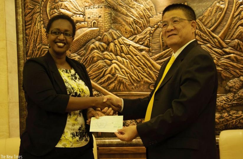 Amb. Pan Hejun gives $ 30,900 cheque to Urujeni Bakuramutsa, the Director General of Imbuto Foundation. (Teddy Kamanzi)