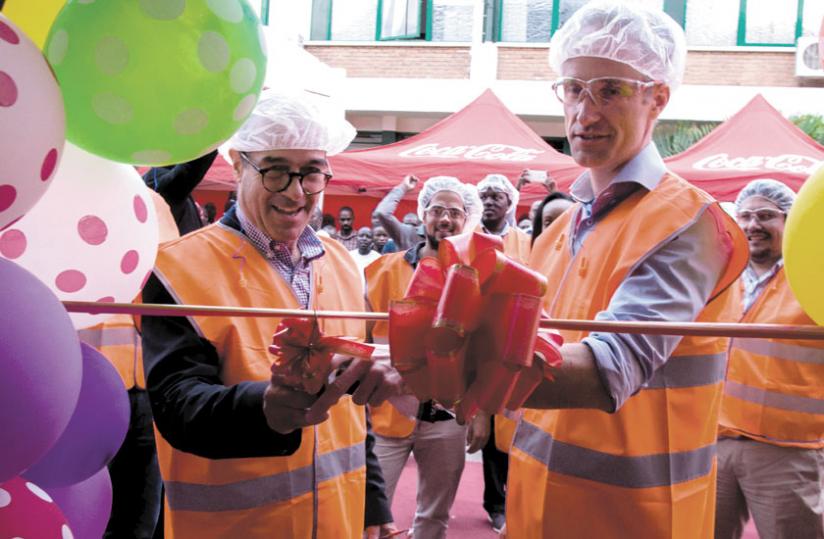 Jonathan Hall (L), the Vice Chairman of the Board and Managing Director of Bralirwa cuts the ribbon during the launch of PET line in Kigali yesterday.  (Teddy Kamanzi)