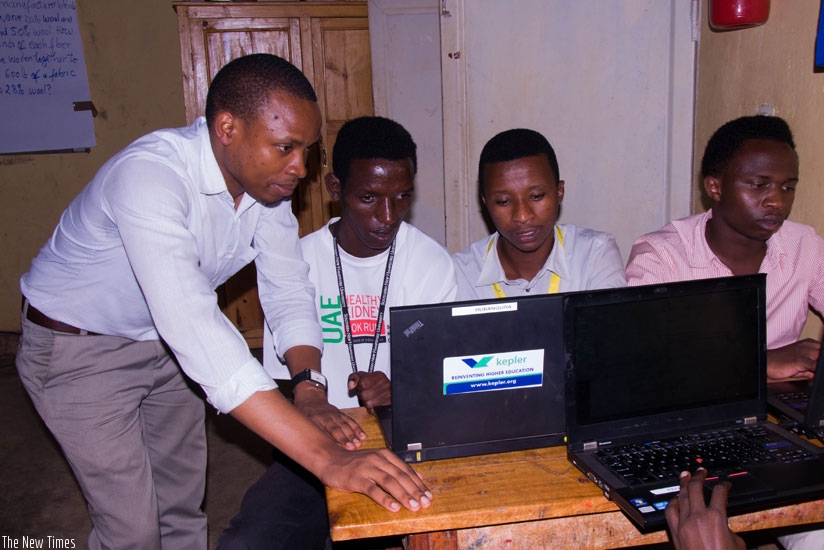 An instructor at Kepler Kiziba helps the students with computer work. (Teddy Kamanzi)