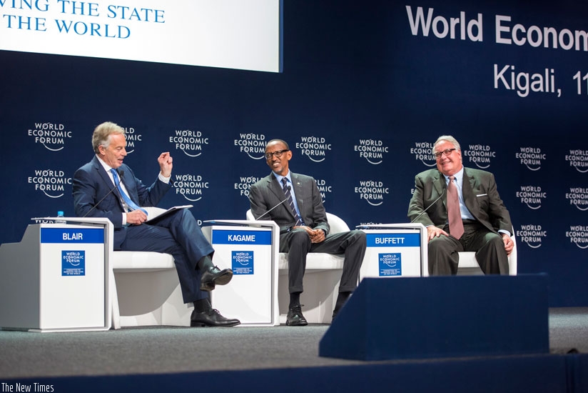President Kagame and US philanthropist Howard Buffett (R) follow through submission of former British Prime Minister Tony Blair during a panel discussion at WEF meeting in Kigali y....