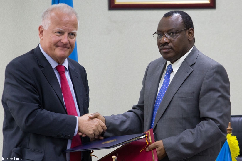 German Ambassador to Rwanda Peter Fahrenholtz (L) and Finance and Economic Planning minister Claver Gatete exchange documents after signing an agreement worth Rwf13 billion to support energy supply in Rwanda and the Great Lakes region. (Timothy Kisambira)