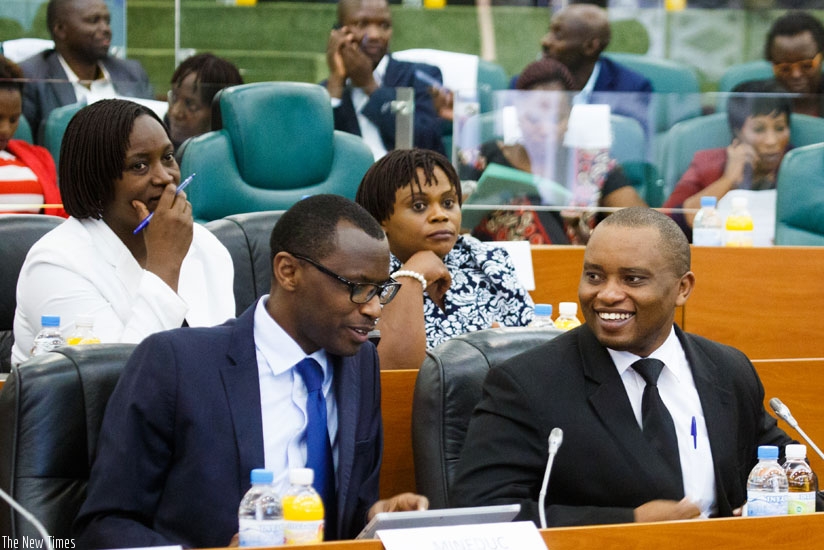 Minister Musafiri (L) chats with Olivier Rwamukwaya, the state minister for primary and secondary education, during the meeting at Senate last week. (Timothy Kisambira)