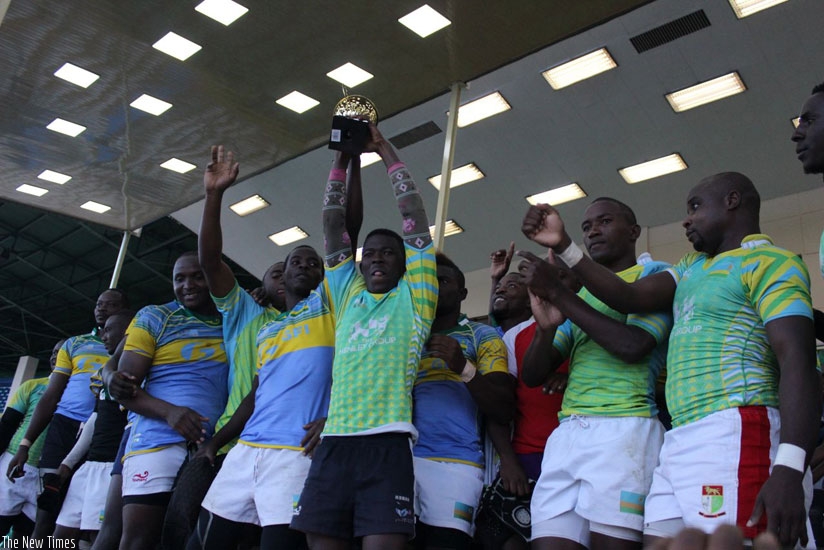 Scrumhalf Patrick Ikorukwishaka lifts the trophy as the team celebrates the final (Stephen Kalimba) 