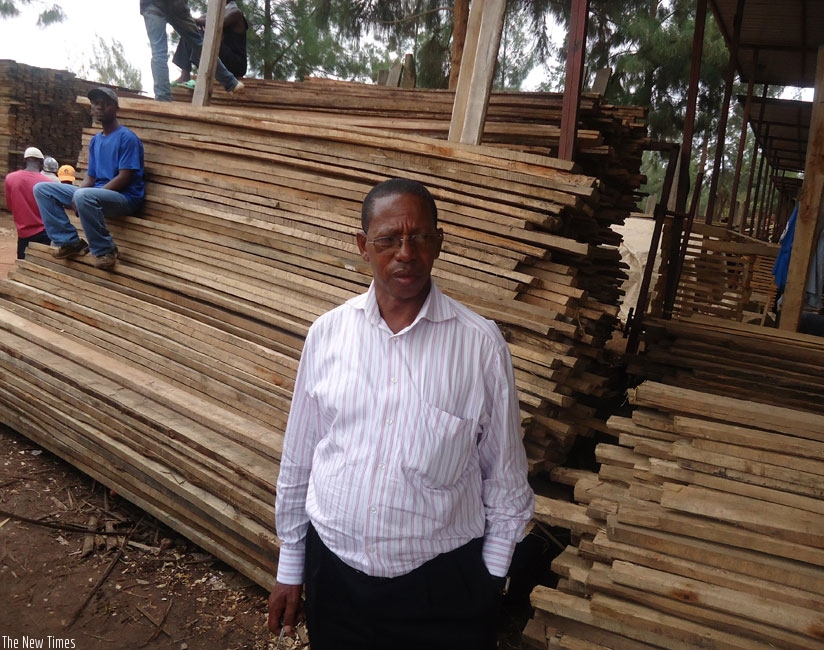 Justin Gashayija, the president of Adarwa Co-operative Society, stands by a timber stall in this 2013 photo. Timber dealers from across the country want the tax body to revise downwards the VAT rate. (File)