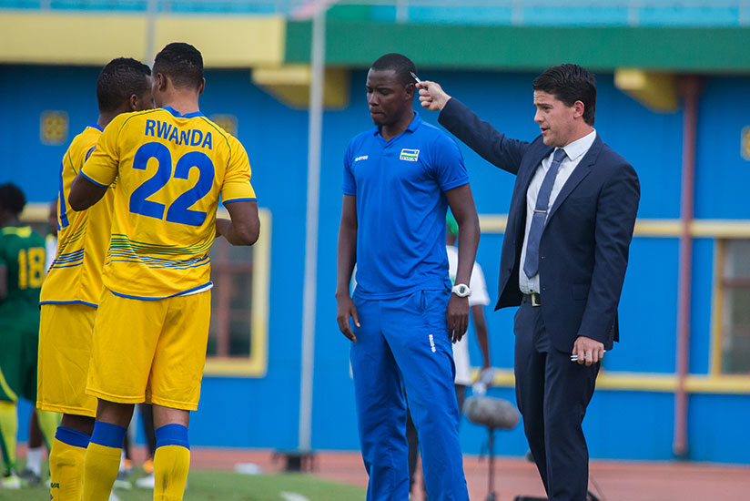 Amavubi head coach Johnathan McKinstry speaks to his players on a touch line. (Timothy Kisambira)