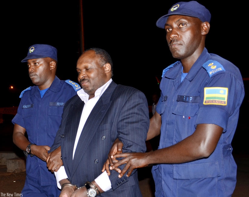 Mbarushimana is led by Rwanda National Police officers following his extradition from Denmark in July 2014. (File)