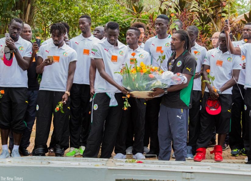 Team captain Cheikhou Kouyate and head Coach Aliou Cisse lead the team to lay a wreath on one of the mass graves at Gisozi Genocide Memorial. (F. Niyigena)