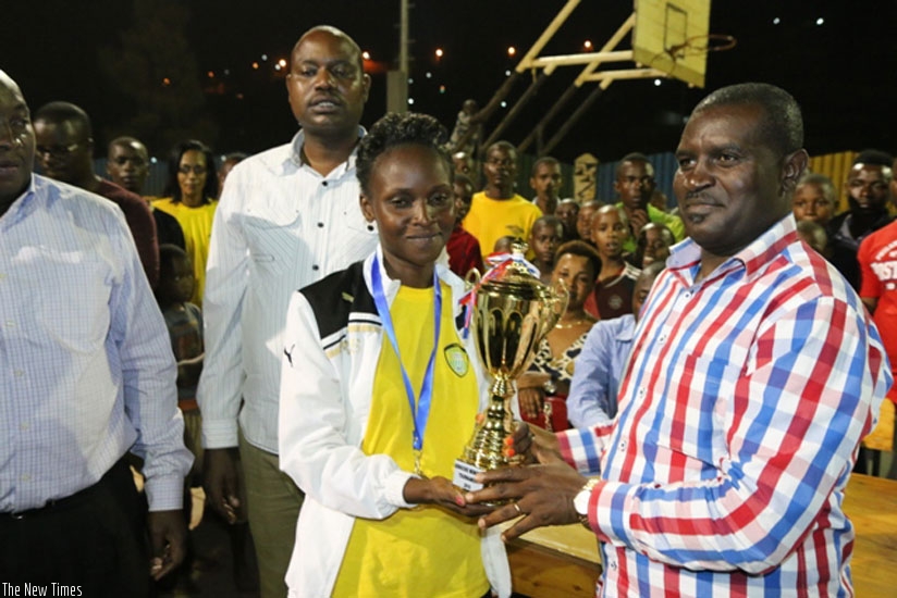 Gorillas captain Gatesi Confiance recieves the the trophy from Emmanuel Bugingo Director of Sports in the Ministry of Sports and Culture. (Geoffrey Asiimwe)