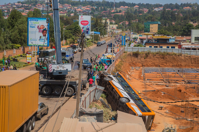 The truck hit this Royal Express bus which was parked awaiting passengers before ramming into another bus. Here, Police were trying to remove the bus that had plunged into a nearby construction site. (Faustin Niyigena)