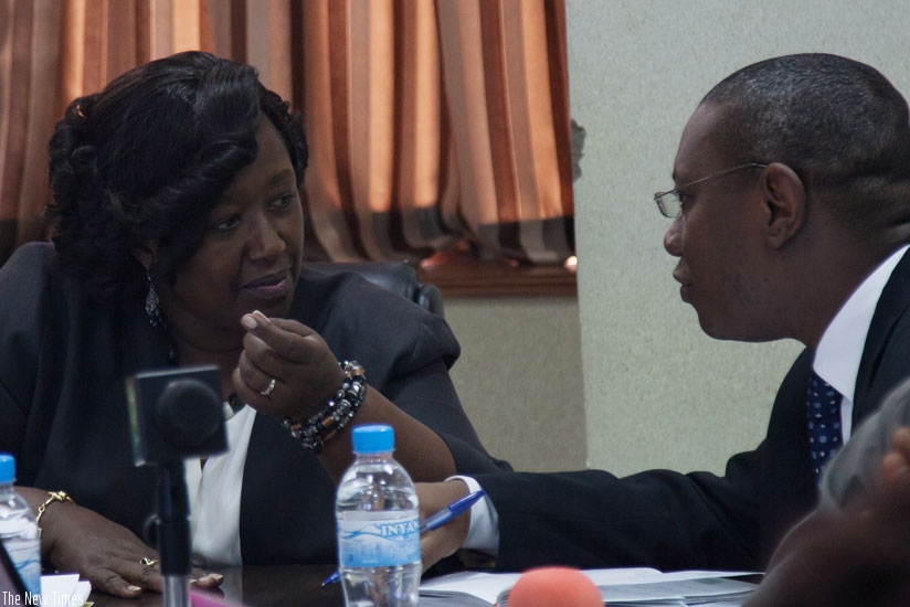 Minister Binagwaho (L) consults with Dr Patrick Ndimubanzi,  the State Minister in charge of Public Health and Primary Health Care, during the news conference in Kigali. (Nadege Imbabazi)