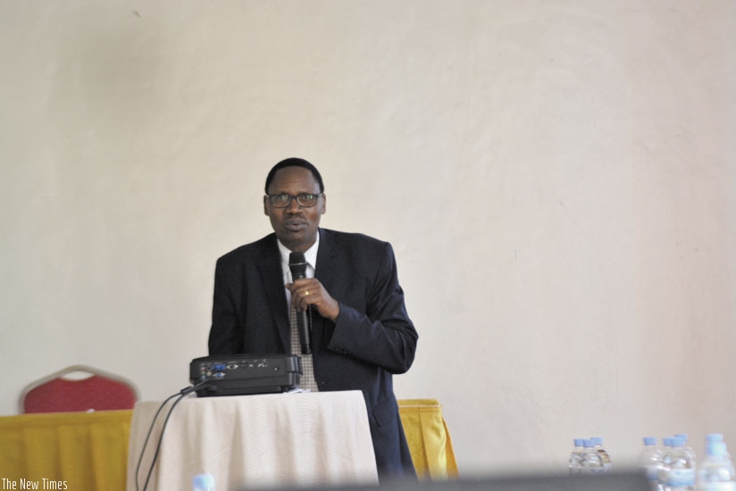 Prof Cyprien Niyomugabo, the chairman of Rwanda Academy of Languages and Culture speaking at the event. Right is the Kinyarwanda biology dictionary to be published soon. (Francis Byaruhanga)