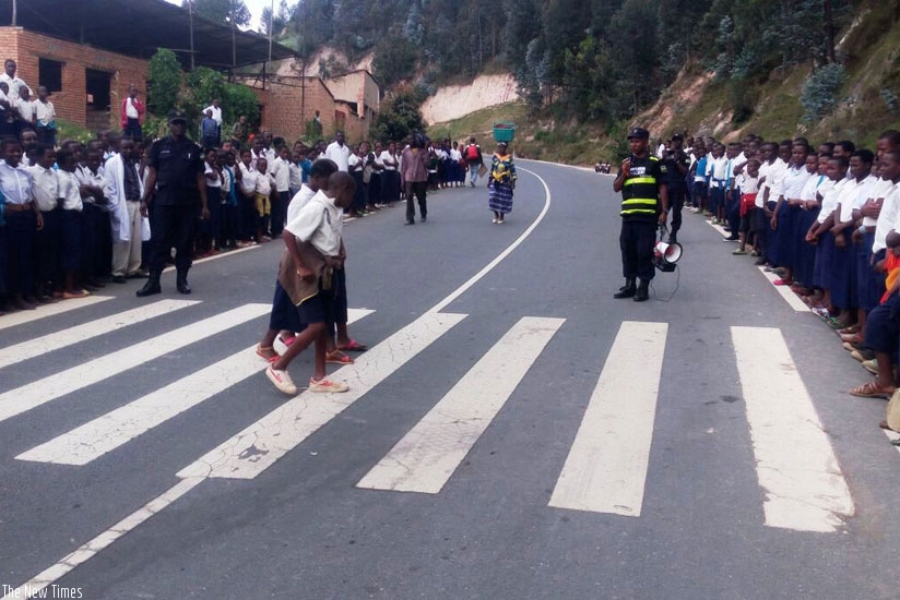 Traffic and Road Safety Police officers in Ngororero District teach school children how to use zebra crossing as part of Police Week, that entered its final stages yesterday with emphasis on the well-being of children and road safety. (Courtesy)