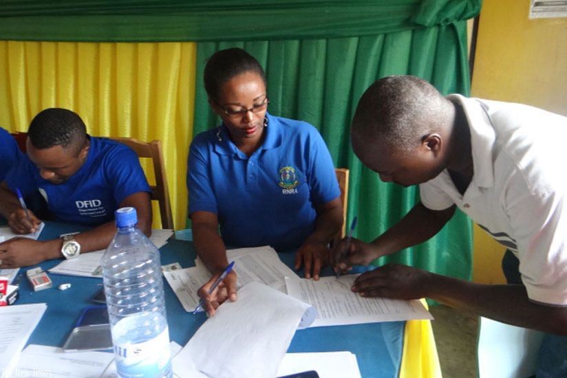 Land registration officers help Kamonyi residents register their property in order to get land titles. (Frederic Byumvuhore)