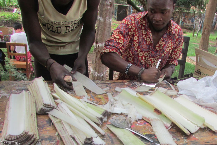 Mugisha works with other youth on the project. Above some of the youth cut banana stems into smaller pieces. (Joseph Oindo)