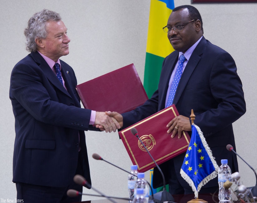 EU Ambassador Michael Ryan (L) exchanges documents with  finance minister Claver Gatete in Kigali. (T.Kisambira)