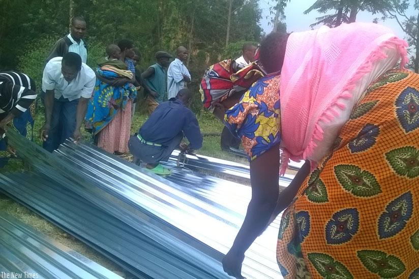 Gakenke woman picks her iron sheets she received from the World Vision on Thursday. (J.D Mbonyinshuti)