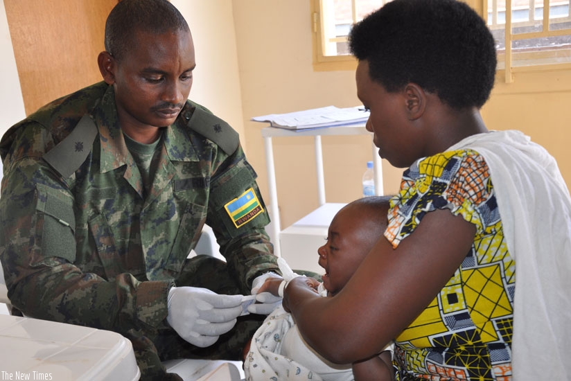 An army doctor treats a child at Nyamata Hospital. (Frederic Byumvuhore)