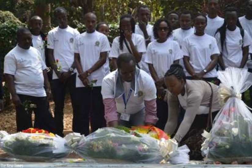 Dr. Cheruiyot and Staff lay a wreaths on the mass graves as students watch. 