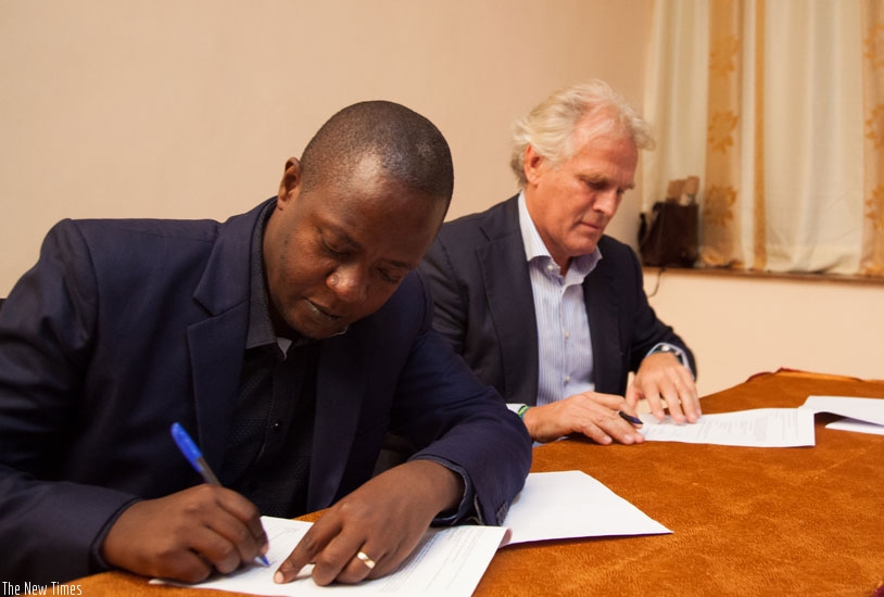 Emmaneul Kamanzi, the EDCL managing director, signs documents with Bart Hartman, NOTS chief entrepreneur, in Kigali on Thursday. (Nadege Imbabazi)