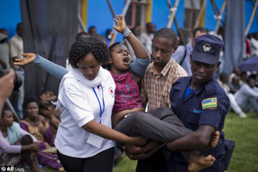A traumatised survivor is helped at a past Genocide commemoration event at the Amahoro National Stadium in Kigali. (T. Kisambira)