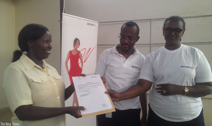 Employees of Access Bank giving document of payment confirmation to Genevieve Uwamahoro, the Executive Secretary of Nyarugunga Sector. (Frederic Byumvuhore)