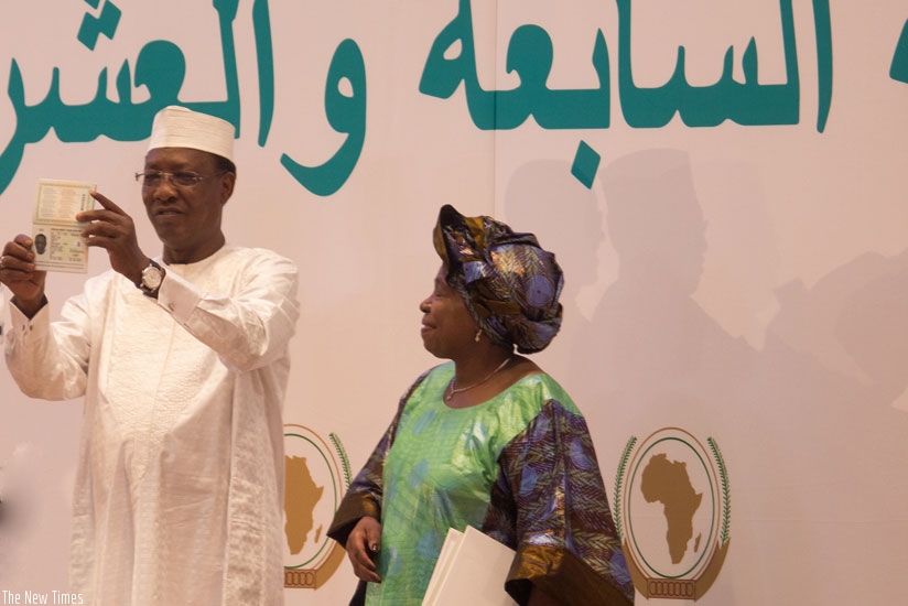 President Idriss Deby of Chad shows off his African passport at the AU Heads of State Summit in Kigali yesterday. Looking on is outgoing AU Commission Chairperson Dr Nkosazana Dlamini-Zuma. / Timothy Kisambira.