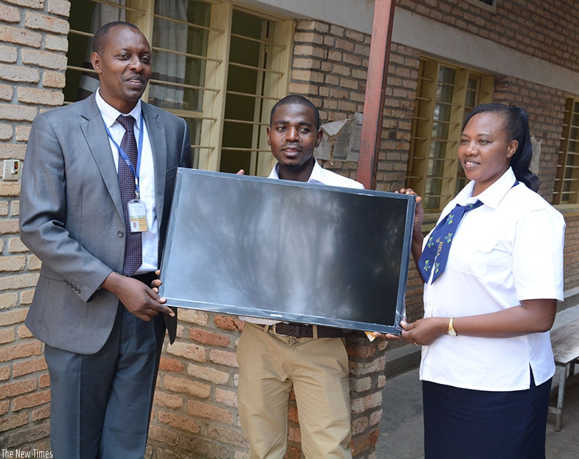 Ntarwerero receives a TV screen from Mbera (left) and Mary Mukarwego, the principal revenue officer at RRA Muhanga District branch, at the event. / Appolonia Uwanziga.