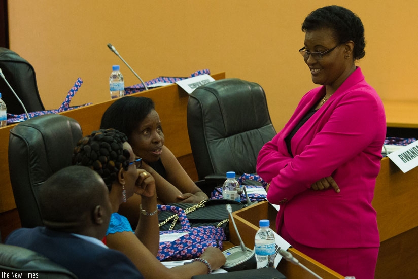 Speaker Mukabalisa (R) chats with MPs before the meeting at Parliament yesterday. (Timothy KIsambira)