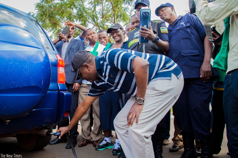 The Minister for Natural Resources, Dr Vincent Biruta, tests levels of carbon emissions from a car as police officers verify if the results match with the environmental standards. / File