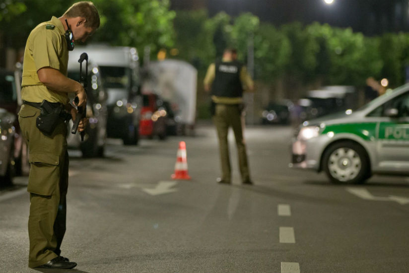 A policeman stands near the scene after a man was killed and 11 others were injured in an explosion in Franconia Ansbach. / Daniel Karmann/EPA