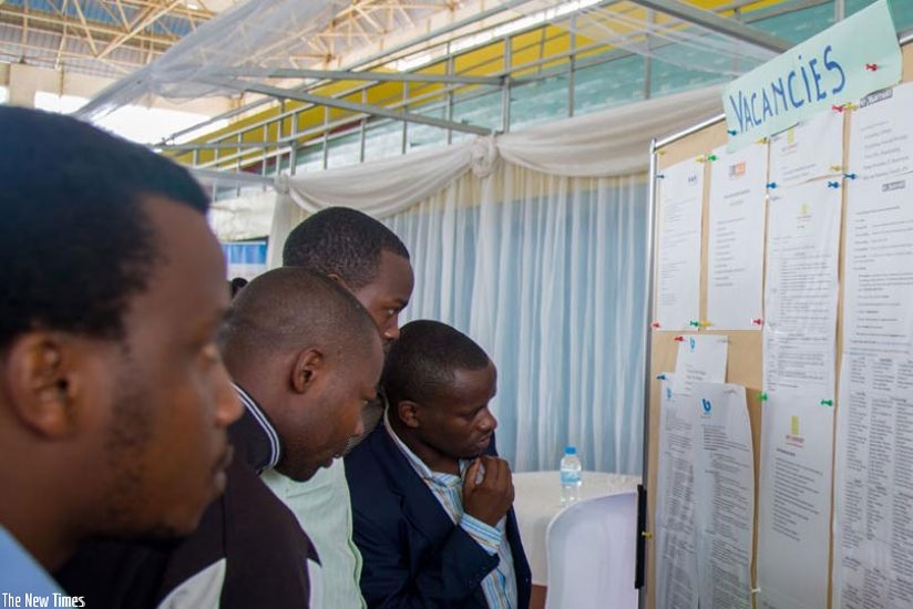 Jobseekers look for job opportunities on a notice board displayed at the third Kigali Employment Fair at Petit Stade in Remera, Kigali earlier this year. (File.)