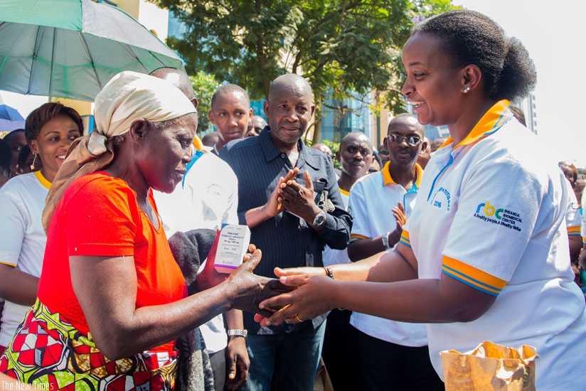 RBC director general Dr Jeanine Condo shakes hands after giving free medicine to a Hepatitis patient during the event to mark World Hepatitis Day at Kigali Car-Free Zone on Thursda....