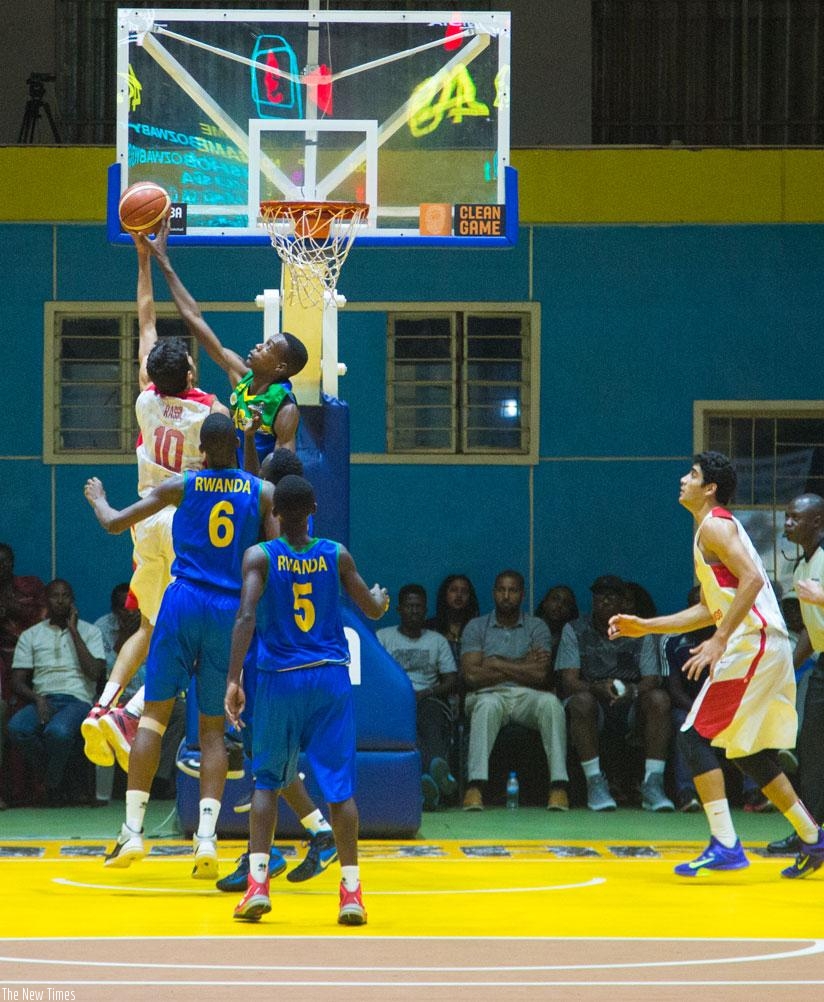 Osborn Shema of Rwanda blocks Mohamed Rassil Adam of Tunisia during the fourth quarter of their quarter-final game of the 2016 FIBA-Africa U18 Championship at Amahoro indoor stadiu....