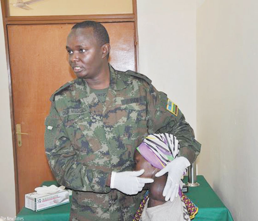 A medic from Rwanda Military Hospital attending to a patient with goiter. / File photo.