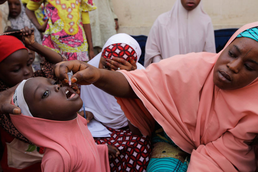 A Nigerian health official administers a polio vaccine to a child in Kano, northern Nigeria. / Internet photo.