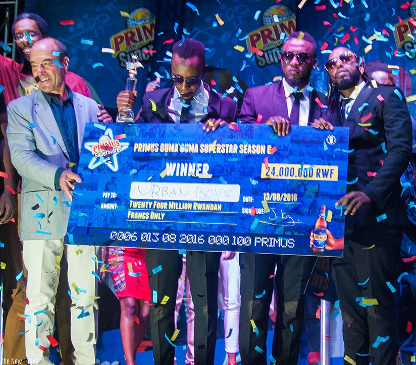 Jonathan Hall, Managing Director, BRALIRWA Ltd with Urban Boys after winning Guma Guma season 6. / Nadege Imbabazi.