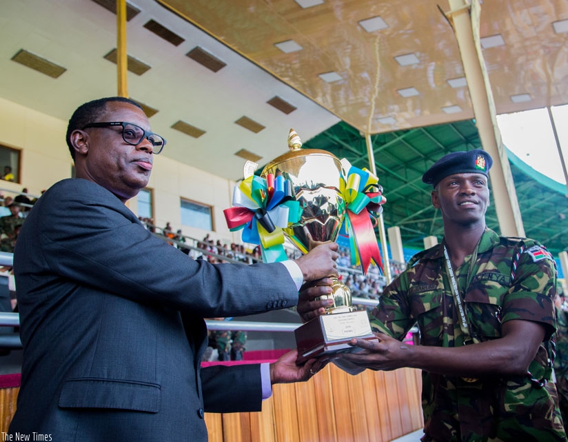 Defence minister James Kabarebe hands over the football trophy to a representative of Kenya Defence Forces team during the closing ceremony of the 10th EAC Military Games at Amahor....