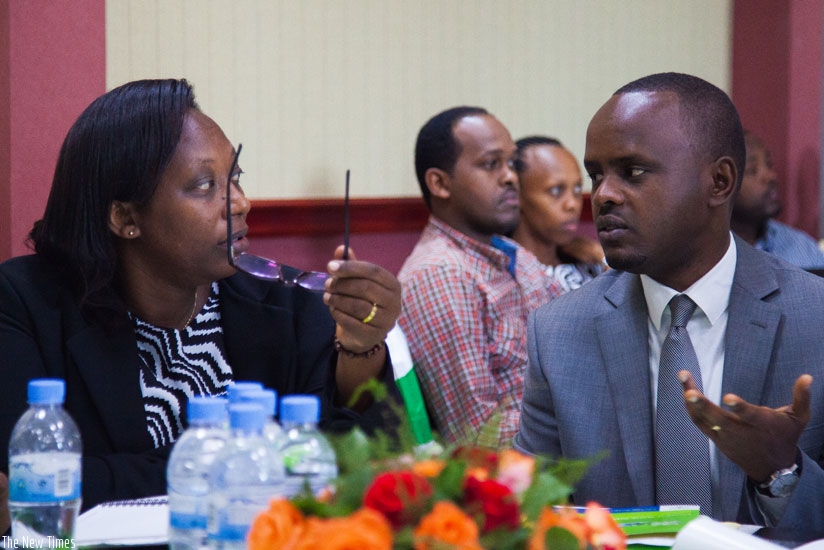 Nsanganira (R) speaks to Uwumukiza at the launch of the new online portal expected to reduce the cost of importing and exporting agricultural produce in Kigali, yesterday. / Nadege Imbabazi. 