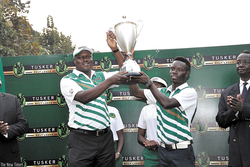 Uganda Breweries Managing Director Mark Ocitti presents the Tusker Malt Uganda Open trophy to Ronald Otile. (Courtesy)