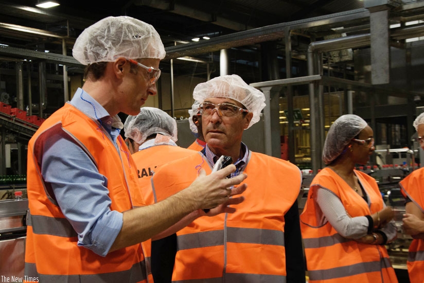 Hall (middle) listens to a plant engineer at the launch of the firm's Kigali plant recently.